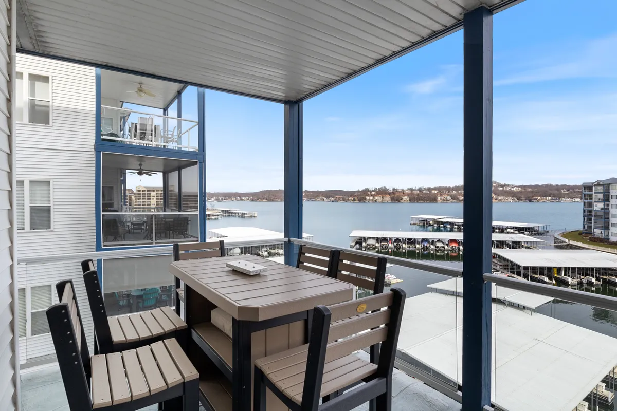 An inviting outdoor dining area with a table and seating overlooking the serene lake. The setting suggests leisurely meals, morning coffee, or sunset gatherings right by the water's edge.